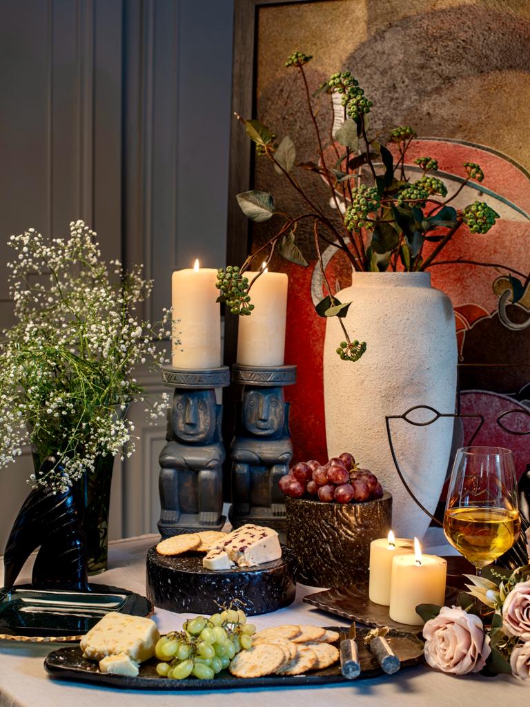 Platter with food with candle stands and vases in the background