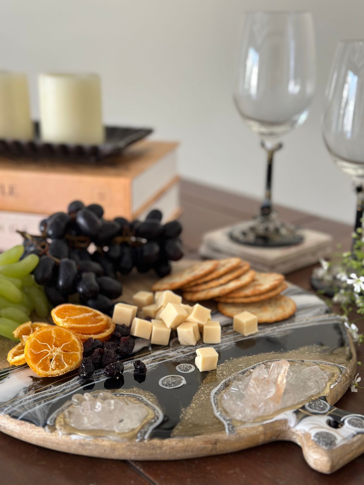 Round Cheese resin board black with food and wine glass in the background