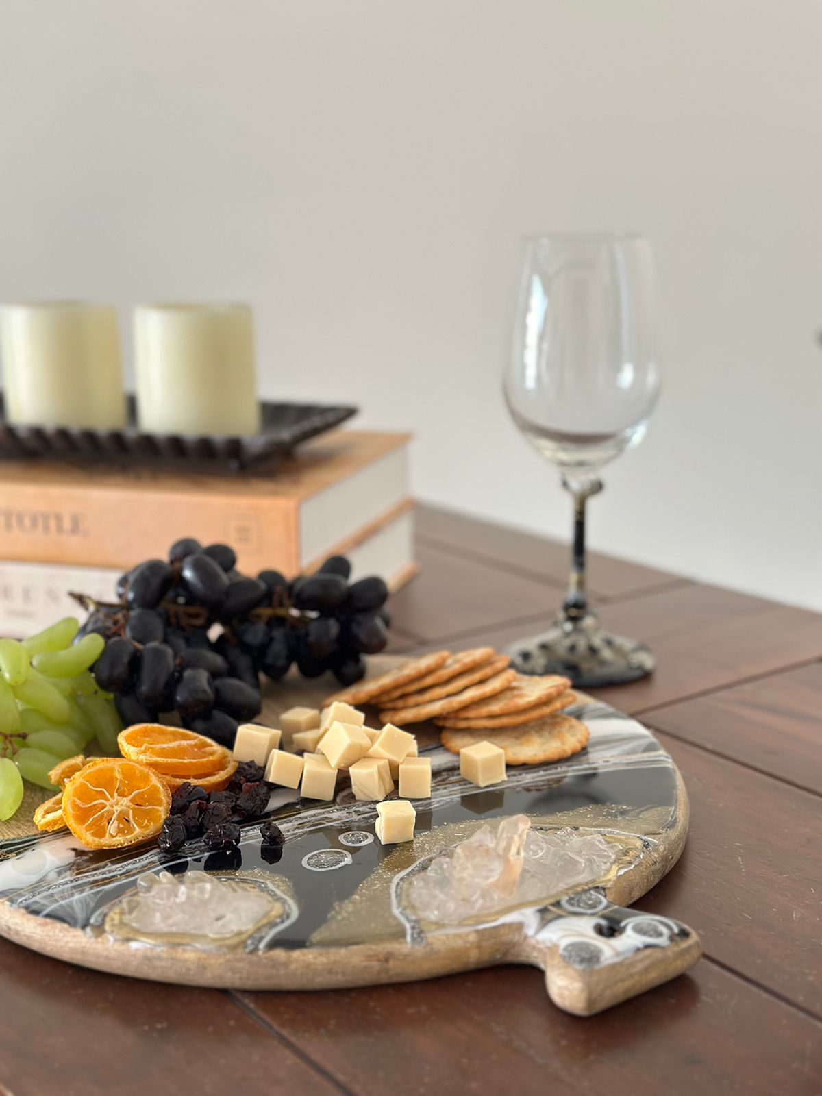 Round Cheese resin board black with food and wine glass in the back