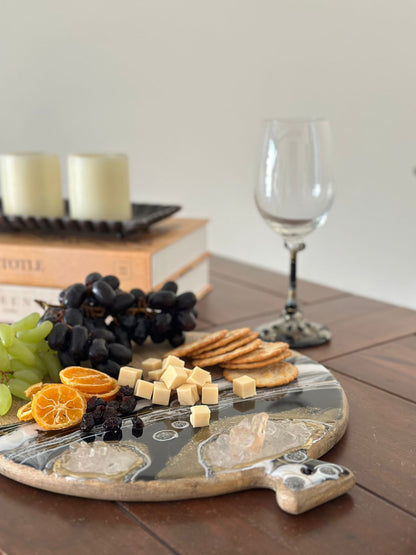 Round Cheese resin board black with food and wine glass in the back