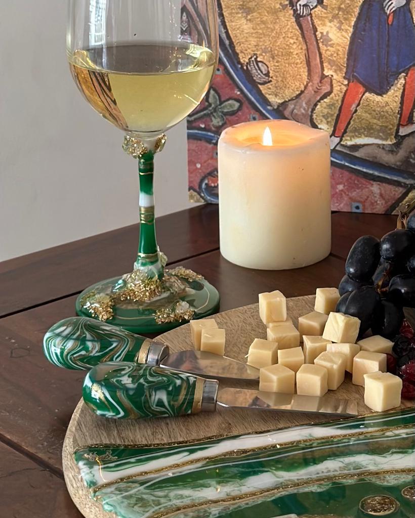 Cheese knives Green with cheese on platter with wine glass and candle in the background